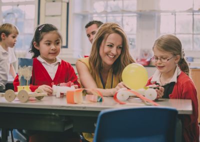 female primary teacher with young uniform pupils